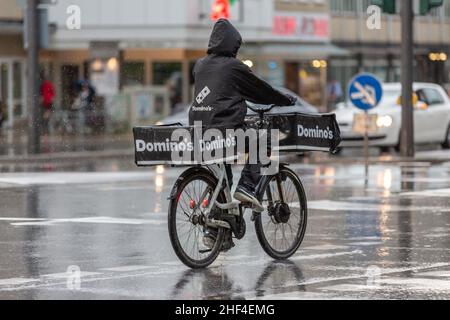 Domino's Pizza Lieferfahrer auf dem Fahrrad im Regen Stockfoto