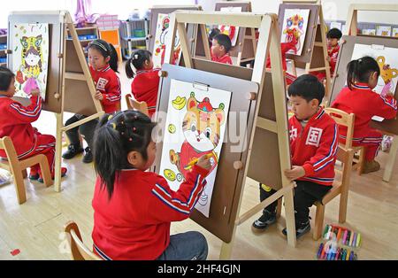 Yantai, Yantai, China. 14th Januar 2022. Am 13. Januar 2022 nähert sich das Frühlingsfest. Der experimentelle Kindergarten im Bezirk Fushan, Stadt Yantai, Provinz Shandong, führte reiche und farbenfrohe Volksaktivitäten durch, um die Kinder den Charme der traditionellen Kultur spüren zu lassen und die Ankunft des Frühlingsfestes des Jahres des Tigers im Mondkalender zu begrüßen. (Bild: © SIPA Asia via ZUMA Press Wire) Stockfoto