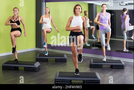 Junge, fitge Frauen trainieren mit Sprungplattformen im Fitnessstudio Stockfoto