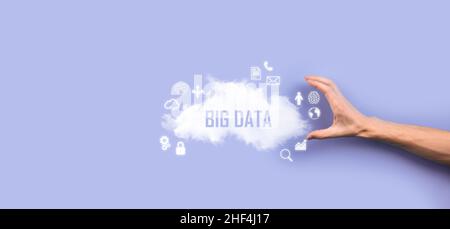 Geschäftsmann hält die Inschrift , Wort BIG DATA . Vorhängeschloss, Gehirn, Mann, Planet, Graph, Lupe, Zahnräder, Symbol für Cloud, Grid, Dokument, Brief, Telefon Stockfoto