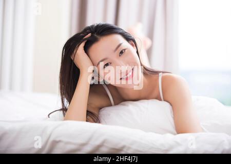 Junge Frau im Bett liegend Stockfoto