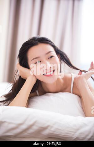 Junge Frau im Bett liegend Stockfoto