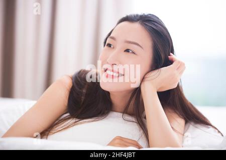 Junge Frau im Bett liegend Stockfoto