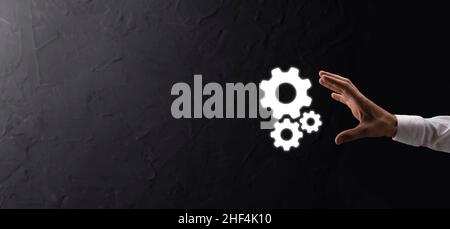 Hand hält Metall Zahnräder und Zahnräder Mechanismus der Interaktion Teamwork Konzept, Hand halten Gruppe von virtuellen Zahnräder Rad. Stockfoto