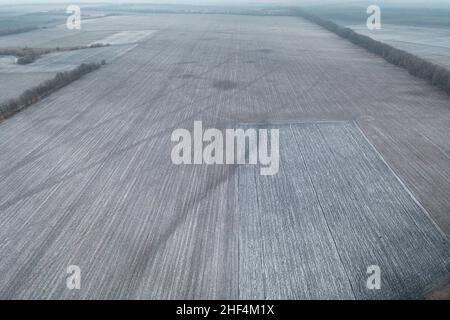 Topographische Aufnahme von landwirtschaftlichen Grundstücken für die Landwirtschaft. Agrarland für die Agrarindustrie. Topographische Aufnahme des Winterfeldes. Leeres Feld ist Ackerland: Drohnenansicht. Stockfoto