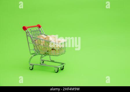 Einkaufswagen, gefüllt mit Holzwürfeln. Das Konzept des Einkaufs von Holzsortimenten. Stockfoto