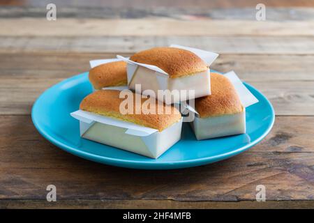 Mantecadas handgemachtes typisch spanisches Dessert. Cupcakes mit blauem Teller auf Holzhintergrund. Speicherplatz kopieren. Stockfoto