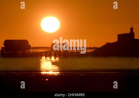 Sonnenaufgang über Mumbles Pier und Leuchtturm Stockfoto