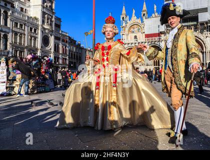 Fotografen werfen Schatten auf einen Teilnehmer, der sich als extravagante Rokoko-Barockkönigin in Kostümen, Karneval von Venedig, Carnevale di Venezia, Italien, posiert Stockfoto