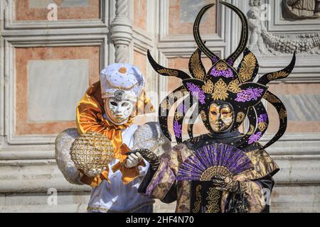 Teilnehmer in farbenfrohem arlecchino Harlekin Wahrsager Kostüm und mythischem orientalischen Outfit Pose, Carnevale Di Venezia, Karneval in Venedig, Italien Stockfoto