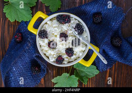 Frischer Hüttenkäse mit frischen Brombeeren in einer Schüssel Stockfoto