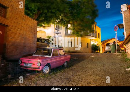 Geparkte Rarität Tuning Pink Minicar Zaporozhets Auf Gepflasterter Straße Im Alten Bezirk Von Tiflis, Georgien Stockfoto