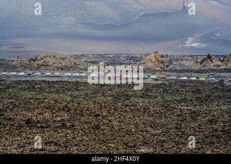 Die Leute fahren mit gemieteten Autos in den timanfaya Nationalpark, um die vulkanische Landschaft zu sehen Stockfoto