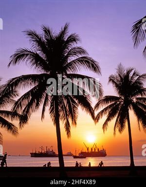 Philippinen. Manila. Sonnenuntergang über der Bucht von Manila mit Handelsschiffen. Stockfoto
