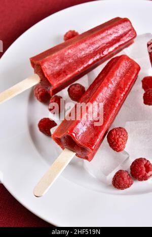 Himbeer-Eis-Eiszapfen auf weißem Teller. Nahaufnahme Stockfoto