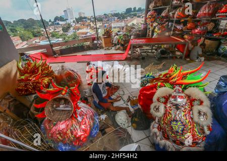 Ein Handwerker, der Löwen (Barongsai) und Drachen (Liong) tanzt, inspiziert seine Kreationen in seinem Haus vor den Feierlichkeiten zum Mondneujahr Stockfoto