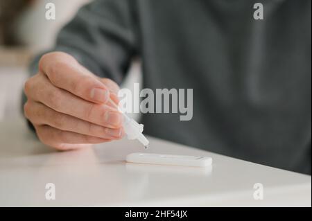 Crop anonymen Mann unter schnellen COVID-Test zu Hause Stockfoto