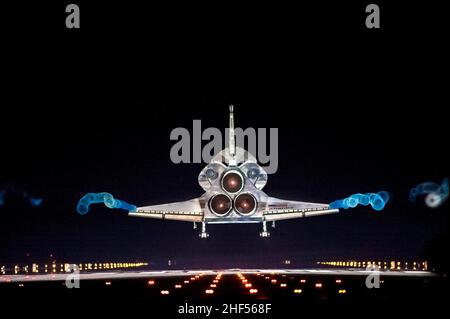 Vapor Trails folgen dem Space Shuttle Atlantis, während es sich der Start- und Landebahn 15 auf der Shuttle Landing Facility im NASAs Kennedy Space Center in Florida nähert. Stockfoto