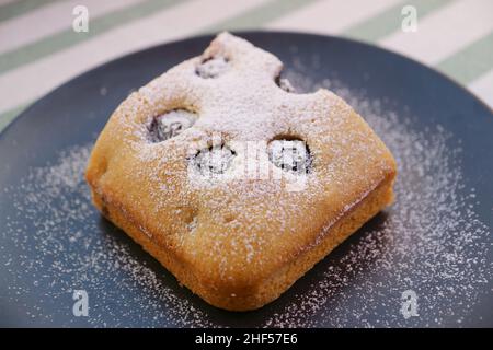 Nahaufnahme ein Stück leckeren und gesunden Blaubeerkuchen auf einem schwarzen Teller Stockfoto