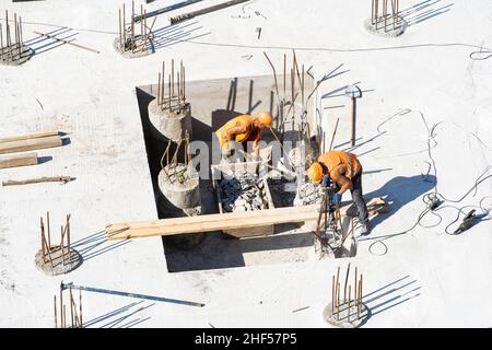 Nahaufnahme des Hausfundaments aus Betonschalungsblöcken, gefüllt mit Mörtel und Verstärkungsstäben Stockfoto