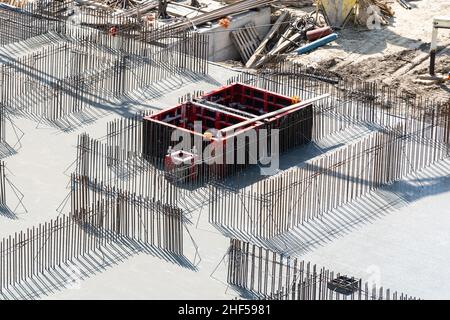 Nahaufnahme des Hausfundaments aus Betonschalungsblöcken, gefüllt mit Mörtel und Verstärkungsstäben Stockfoto