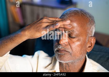 Älterer Mann, der an Kopfschmerzen leidet - Konzept von Stress, Familienproblemen und Krankheit während der Coronavirus-Covid-19-Sperre. Stockfoto