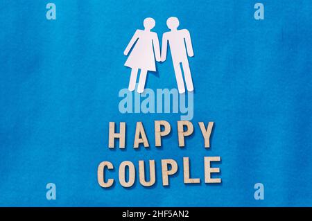 Happy Human Couple Paper Craft Mockup auf blauem Hintergrund. Origami Papercraft dekorative Formen und Figuren. Vertikal. Stockfoto