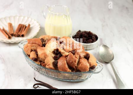 Zimtbrot-Pudding-Frühstücksauflauf mit Vanillesoße auf dem Hintergrund aus weißem Marmor Stockfoto