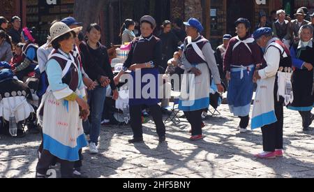 LIJIANG, CHINA - FEBRUAR 20: Nakhi-Frauen tanzen am 20 2012. Februar auf dem Platz in Lijiang. Nakhi sind eine ethnische Gruppe, die die Vorberge bewohnt Stockfoto