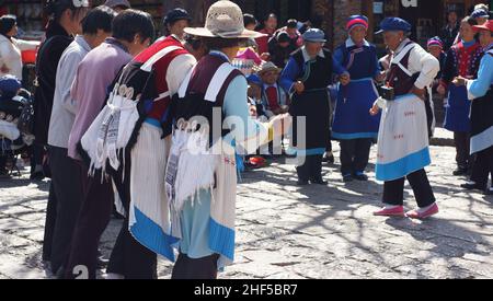 LIJIANG, CHINA - FEBRUAR 20: Nakhi-Frauen tanzen am 20 2012. Februar auf dem Platz in Lijiang. Nakhi sind eine ethnische Gruppe, die die Vorberge bewohnt Stockfoto