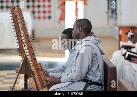 SENEGAL, Benediktinerkloster Keur Moussa, Mönche rezitieren gregorianische Gesänge und spielen während der Messe die afrikanische Kora-Brückenharfe / Senegal, Benediktinerkloster Keur Moussa, Gottesdienst, gregorianische Gesänge mit Kora Saiteninstrument Stockfoto