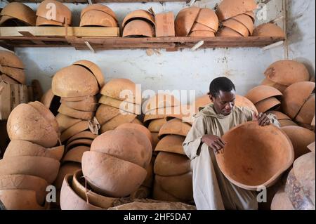 SENEGAL, Benediktinerkloster Keur Moussa, Mönche arbeiten in Werkstatt zur Herstellung der afrikanischen Kora-Brückenharfe, Kalabash für den Klangkörper / Senegal, Benediktinerkloster Keur Moussa, Musikinstrumentbau, Werkstatt, Bau der Kora ein traditionelles westafrikanisches Saiteninstrument, Kalebasse für den Klangkörper Stockfoto