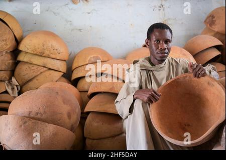 SENEGAL, Benediktinerkloster Keur Moussa, Mönche arbeiten in Werkstatt zur Herstellung der afrikanischen Kora-Brückenharfe, Kalabash für den Klangkörper / Senegal, Benediktinerkloster Keur Moussa, Musikinstrumentbau, Werkstatt, Bau der Kora ein traditionelles westafrikanisches Saiteninstrument, Kalebasse für den Klangkörper Stockfoto