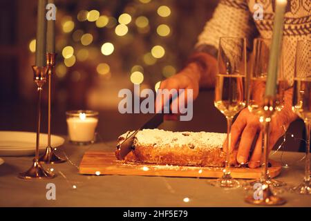 Selektiver Schwerpunkt der weiblichen Schneiden köstliche frisch gebackene hausgemachte xms-Kuchen mit Messer, feiern Heiligabend oder Neujahr mit Freunden oder Familie Stockfoto