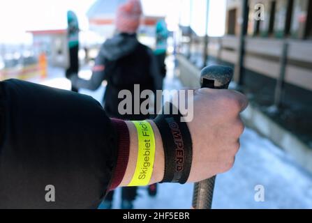 Oberwiesenthal, Deutschland. 14th Januar 2022. Ein Mann hat ein Papierband mit der Aufschrift 'Skigebiet Fichtelberg' am Handgelenk. Nach der koronabedingten Pause öffnen sich die Skigebiete unter hygienischen Bedingungen. Quelle: Sebastian Willnow/dpa-Zentralbild/dpa/Alamy Live News Stockfoto