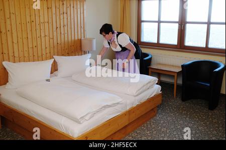 Oberwiesenthal, Deutschland. 14th Januar 2022. Ein Mitarbeiter eines Hotels am Fichtelberg steht in einem Zimmer. Nach der koronabedingten Pause öffnen sich die Skigebiete unter hygienischen Bedingungen. Quelle: Sebastian Willnow/dpa-Zentralbild/dpa/Alamy Live News Stockfoto