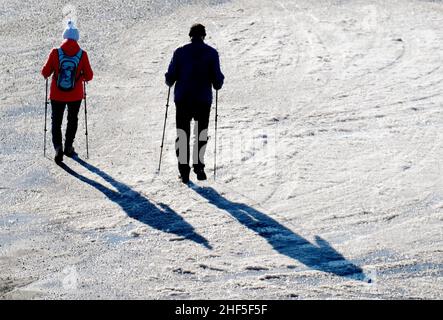 Oberwiesenthal, Deutschland. 14th Januar 2022. Wanderer wandern durch Schnee auf dem Fichtelberg. Nach der koronabedingten Pause öffnet das Skigebiet in Sachsen unter hygienischen Bedingungen. Quelle: Sebastian Willnow/dpa-Zentralbild/dpa/Alamy Live News Stockfoto