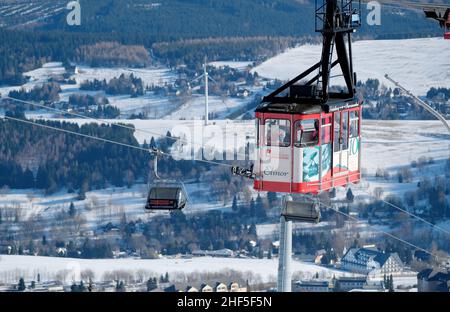 Oberwiesenthal, Deutschland. 14th Januar 2022. Eine Gondelbahn senkt den Fichtelberg. Nach der koronabedingten Pause öffnet das Skigebiet in Sachsen unter hygienischen Bedingungen. Quelle: Sebastian Willnow/dpa-Zentralbild/dpa/Alamy Live News Stockfoto