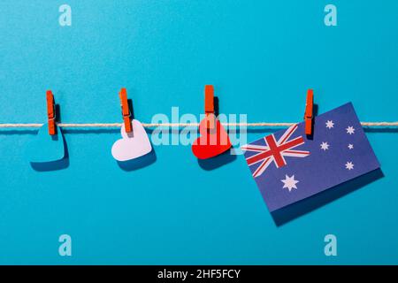 Australien-Flagge mit herzförmigen Papieren auf Wäscheleine auf blauem Hintergrund mit Kopierraum Stockfoto