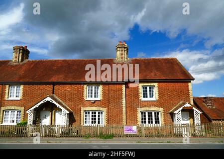 Reihe typischer Ziegelhütten neben B2017 Five Oak Green Road in Tudeley Village, Kent, England Stockfoto