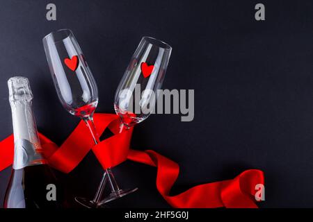 Herzformen in leeren Flöten mit rotem Band von Champagnerflasche verpackt Stockfoto