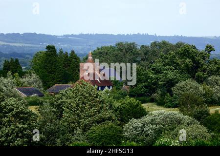 Blick auf die Allerheiligen-Kirche im Dorf Tudeley und die umliegende Landschaft im Frühsommer, vom High Weald Walk-Fußweg aus gesehen, Kent, England Stockfoto