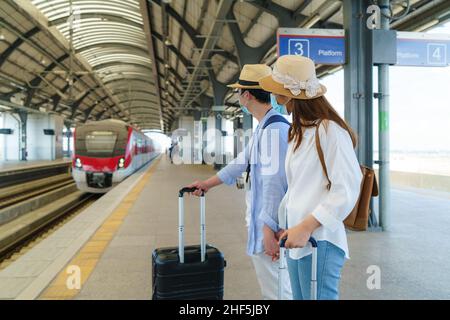 Asiatische Reisende Paar wartet Zug am Bahnhof in Bangkok, Thailand, Reise-und Transportkonzept Stockfoto
