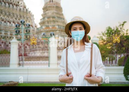 Asiatin mit Maske reist im Wat Arun in Bangkok, Thailand. Stockfoto
