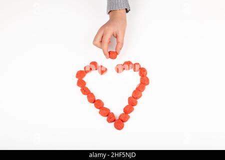 Herz mit Süßigkeiten auf weißem Hintergrund Stockfoto