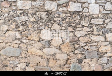 Alte Steinwandstruktur mit verschiedenen Steingrößen. Hintergrund Stockfoto