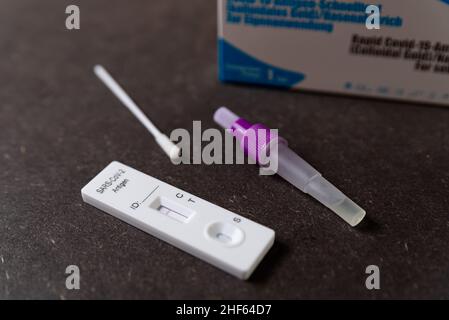 Ein schneller Antigen-Test auf SARS-CoV-2 oder Covid wird auf einem Tisch mit Nasenstäbchen während eines schnellen Bedarfs aufgrund der Omicron-Variante von Cov gesehen Stockfoto