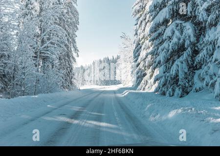 Leere verschneite Straße in den Bergen Stockfoto