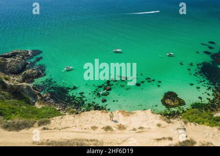 Mann Reisende am Rande vor Bounty Strand mit kristallklarem azurblauem Meer an einem sonnigen Tag. Kap Fiolent in Sewastopol. Luftaufnahme. Stockfoto