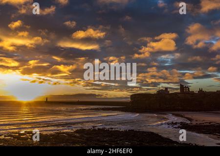 Wunderschöner Sonnenaufgang in Tynemouth's King Edward's Bay mit dem Sonnenlicht, das die Unterseite der Wolken einfängt Stockfoto